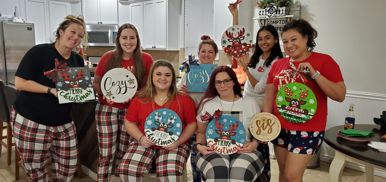 Paint party guests showing their finished holiday projects
