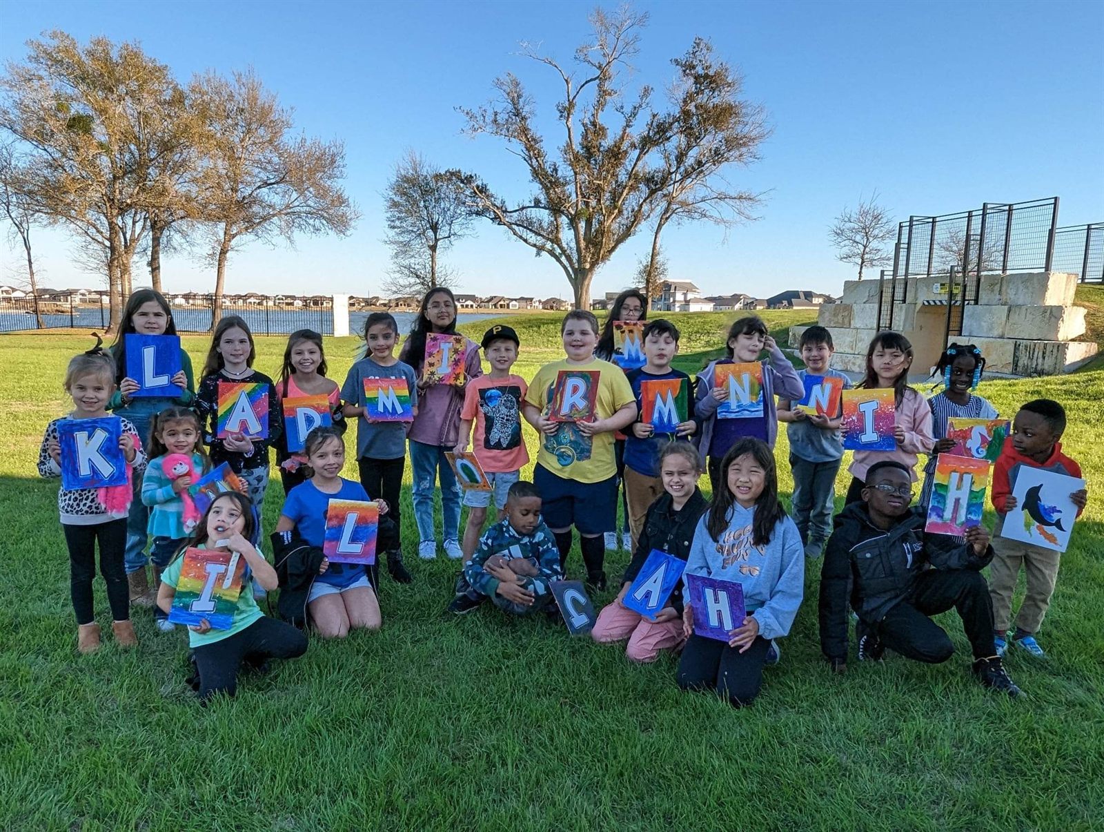 Large group of kids holding finished painted letter projects